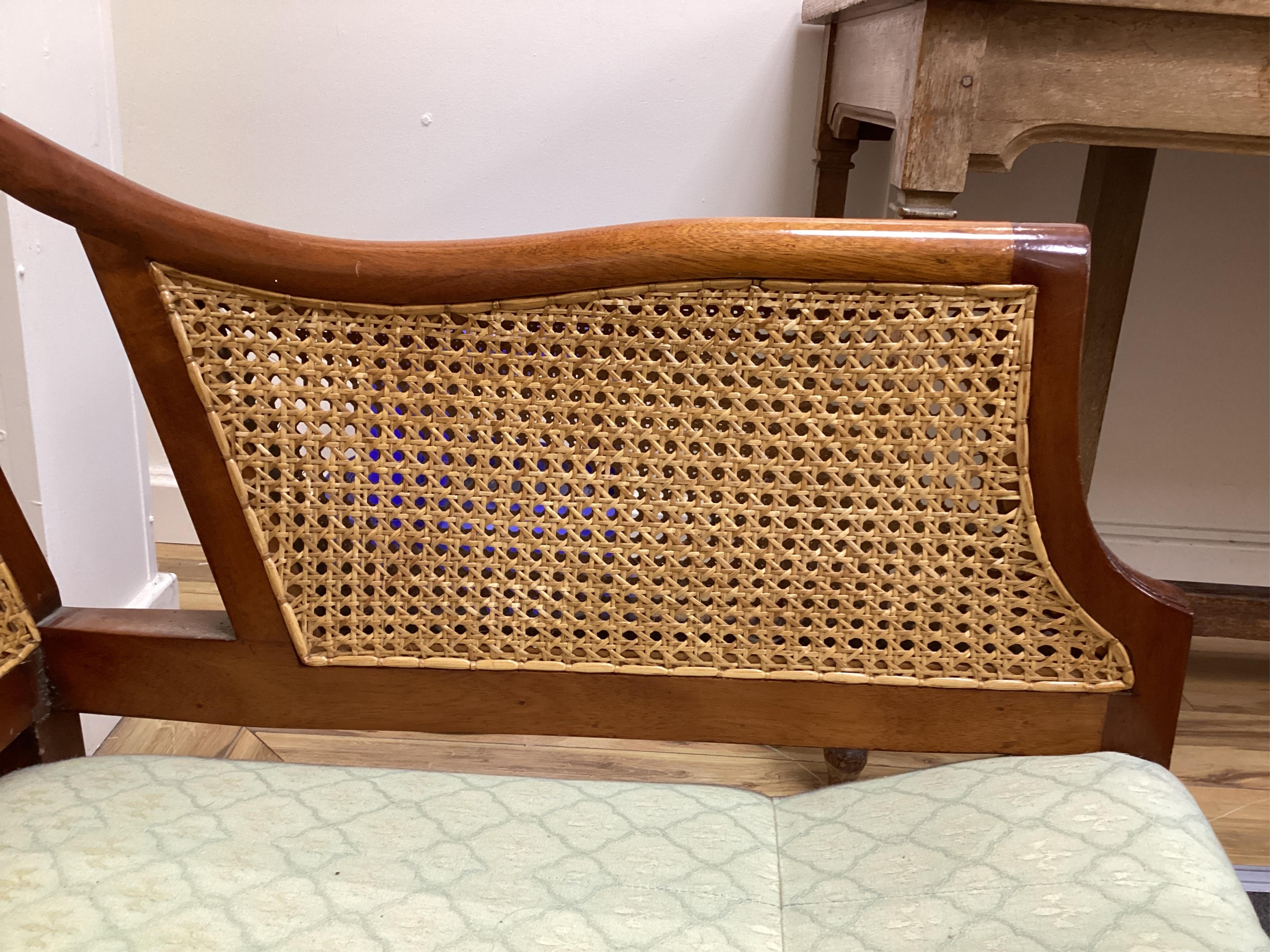 A mahogany double caned bergere settee with loose cushion seat and back, width 178cm, depth 78cm, height 87cm